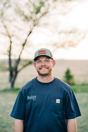The owner of Radiant 307 Plumbing, Remington, standing in front of a custom boiler and tankless hot water system on a residential project
