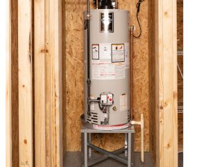 A new install of a tanked water heater on a stand in a home's basement