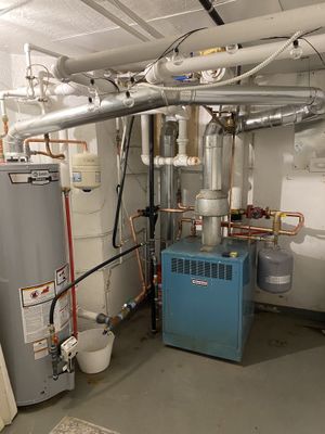 A 1980s model cast iron boiler in a home's basement upgraded with pumps and air elimination system for hot water baseboard heating