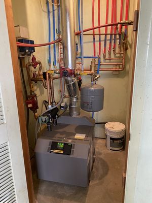 A photo of an older style boiler system - a B-Vent style boiler with baseboard hot water heat.